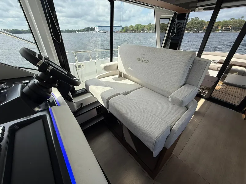 Slide: The Image of 2025 Wellcraft 44 Explorer interior with plush seating and modern helm, overlooking serene waters. - 25