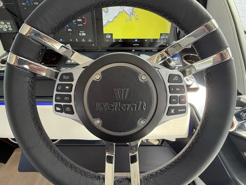 Slide: The Image of Steering wheel of 2025 Wellcraft 44 Explorer boat with control buttons and navigation display. - 27