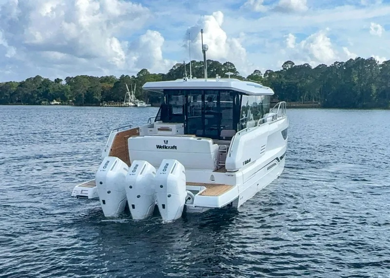 Slide: The Image of 2025 Wellcraft 44 Explorer boat on water with triple outboard engines. - 3