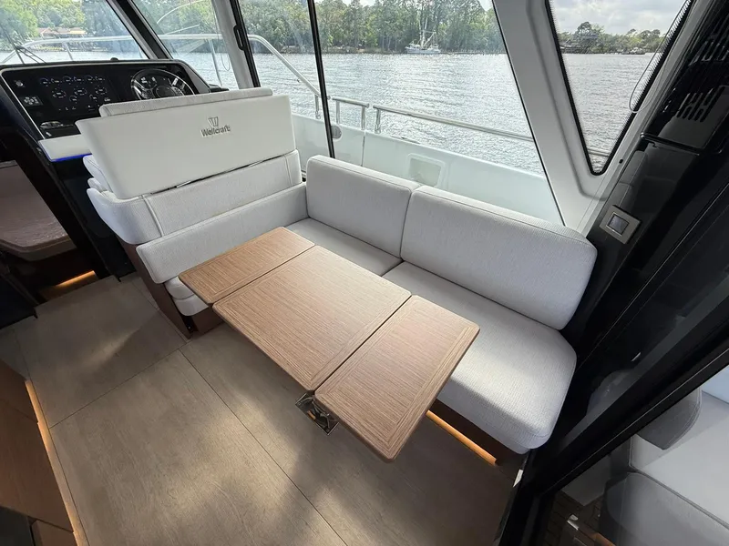 Slide: The Image of 2025 Wellcraft 44 Explorer interior with modern seating and foldable table by the window. - 35