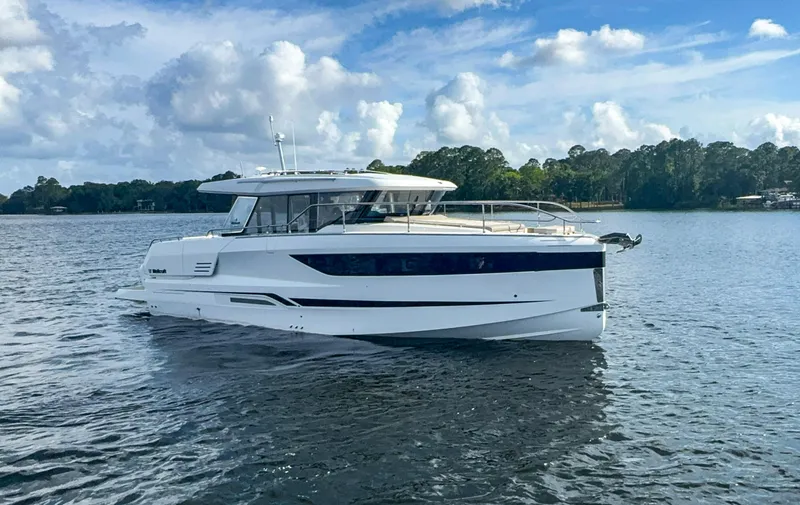 Slide: The Image of 2025 Wellcraft 44 Explorer yacht cruising on a calm lake under a partly cloudy sky. - 6