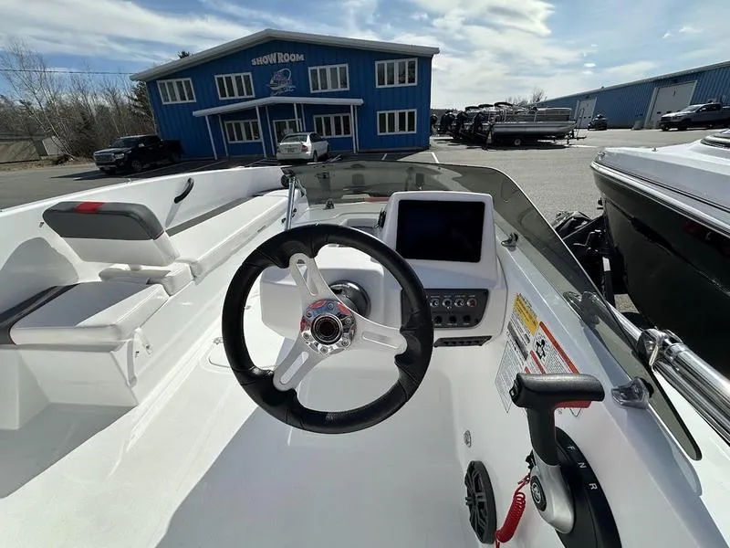 Slide: The Image of 2025 Tahoe T18 boat interior with steering wheel and control panel, outside a blue showroom. - 10