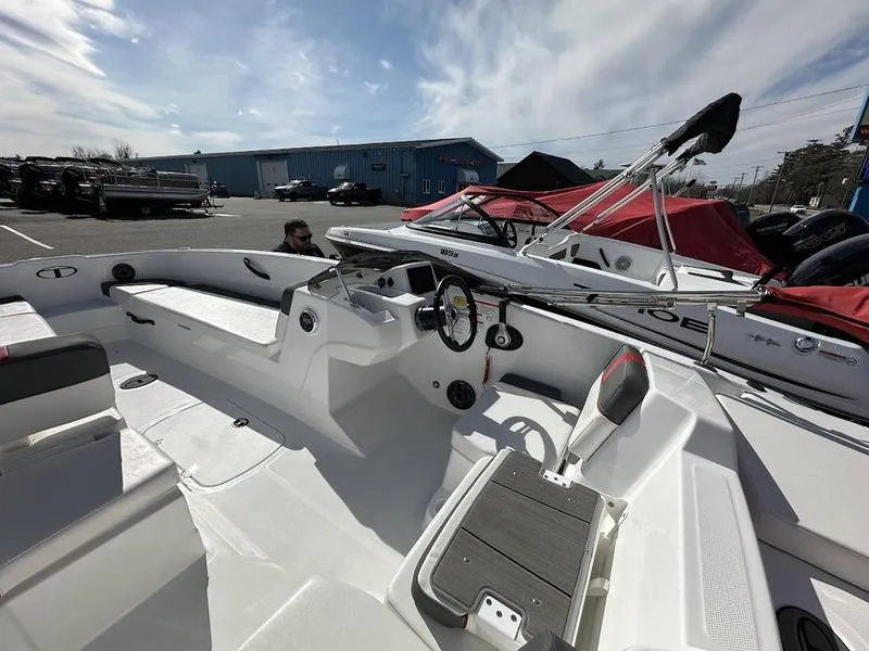 Slide: The Image of 2025 Tahoe T18 boat interior with steering wheel, seating, and docked boats in background. - 11