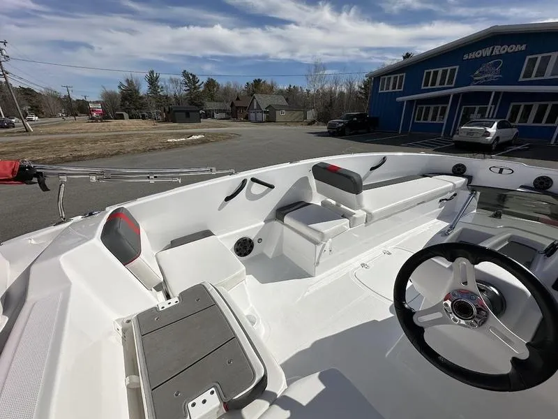 Slide: The Image of 2025 Tahoe T18 boat interior with steering wheel, seating, and outdoor showroom. - 12