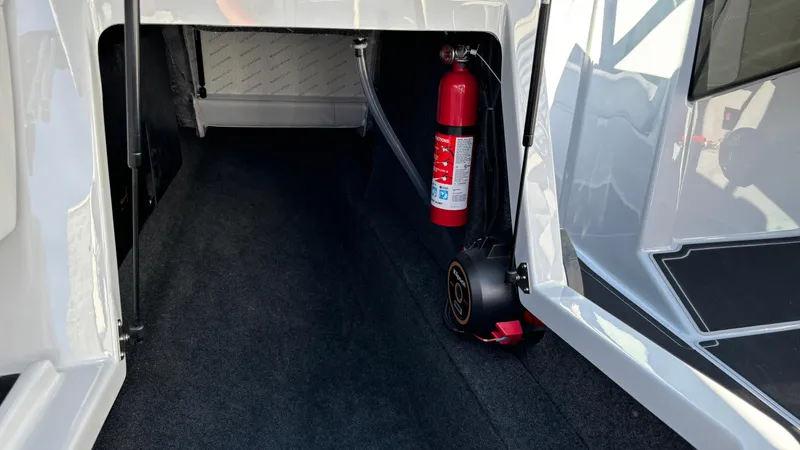 Slide: The Image of 2025 MasterCraft NXT24 storage compartment with fire extinguisher. - 15