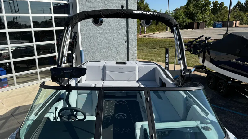 Slide: The Image of 2025 MasterCraft NXT24 boat with sleek design and modern features, parked outdoors. - 18