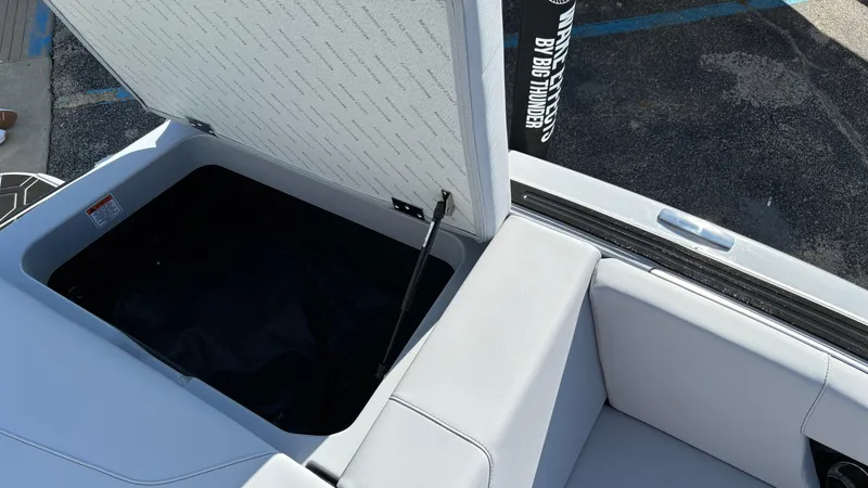 Slide: The Image of 2025 MasterCraft NXT24 boat interior storage compartment with open lid. - 21