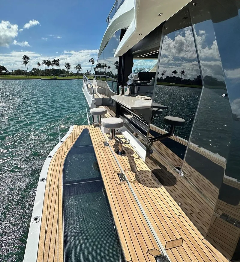 Slide: The Image of 2025 Galeon 560 Fly yacht with sleek deck and bar stools on sunny waters. - 6