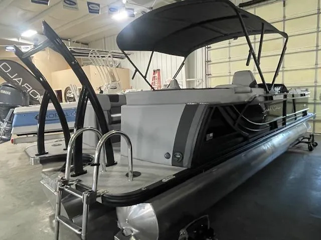 Slide: The Image of 2025 South Bay 500 pontoon boat in showroom with canopy and ladder. - 1