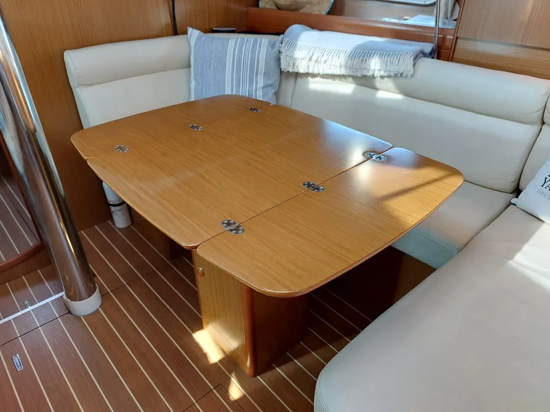 Slide: The Image of Interior of 2006 Jeanneau Sun Odyssey 42 DS with wooden table and cushioned seating. - 21