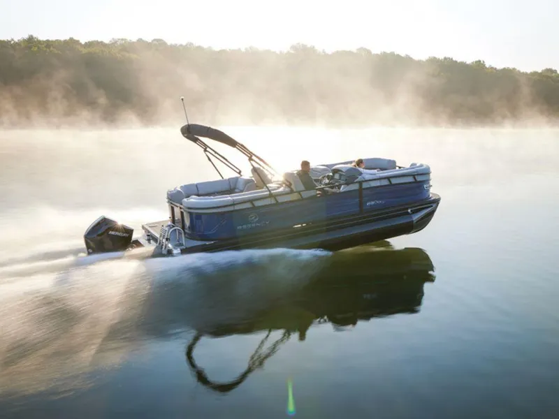 Slide: The Image of 2025 Regency 230 DL3 pontoon boat cruising on a misty lake. - 1