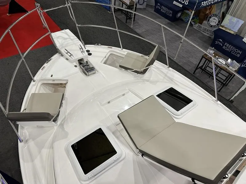 Slide: The Image of 2025 Cutwater C-32 CB LE boat deck with seating and hatches at a boat show. - 19