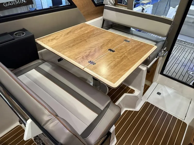 Slide: The Image of Interior of 2025 Cutwater C-32 CB LE boat with wooden table and cushioned seating. - 21