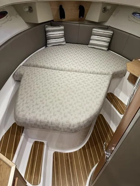 Slide: The Image of 2025 Cutwater C-32 CB LE cabin interior with cushioned bed and striped pillows. - 25
