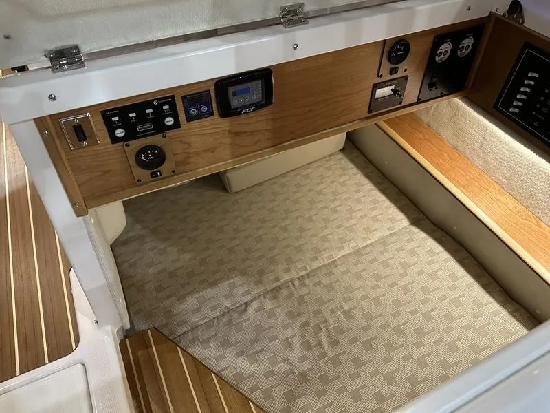 Slide: The Image of 2025 Cutwater C-32 CB LE cabin interior with control panel and cushioned flooring. - 26