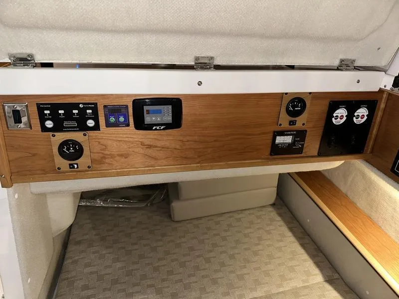 Slide: The Image of 2025 Cutwater C-32 CB LE cabin controls with wood paneling and modern instrumentation. - 28