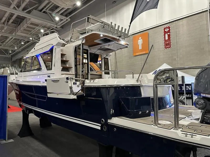 Slide: The Image of 2025 Cutwater C-32 CB LE boat displayed indoors at a boat show. - 5
