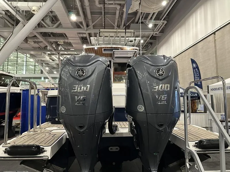 Slide: The Image of 2025 Cutwater C-32 CB LE boat with dual Yamaha 300 V6 engines at indoor exhibit. - 6