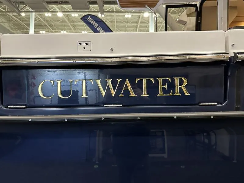 Slide: The Image of 2025 Cutwater C-32 CB LE boat with gold lettering on a dark blue hull. - 7