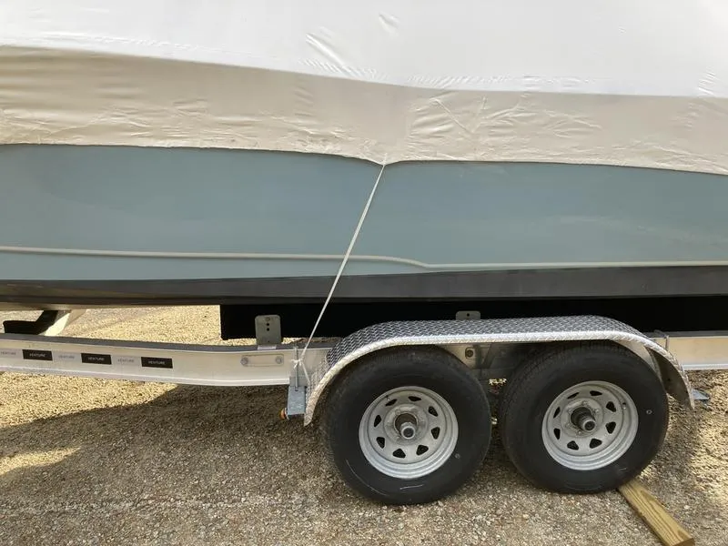 Slide: The Image of 2025 Sea Hunt Ultra 239se boat on trailer, partially covered, side view. - 6