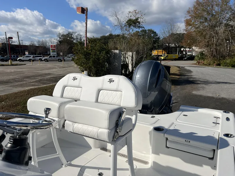 Slide: The Image of 2023 Sea Pro 208 Bay boat with white seating and steering wheel, parked outdoors. - 7