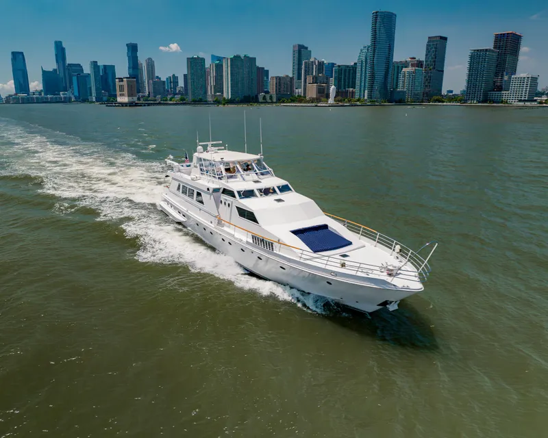 Slide: The Image of Luxury yacht Guy Couach 97 cruising near city skyline, 1987 model. - 0