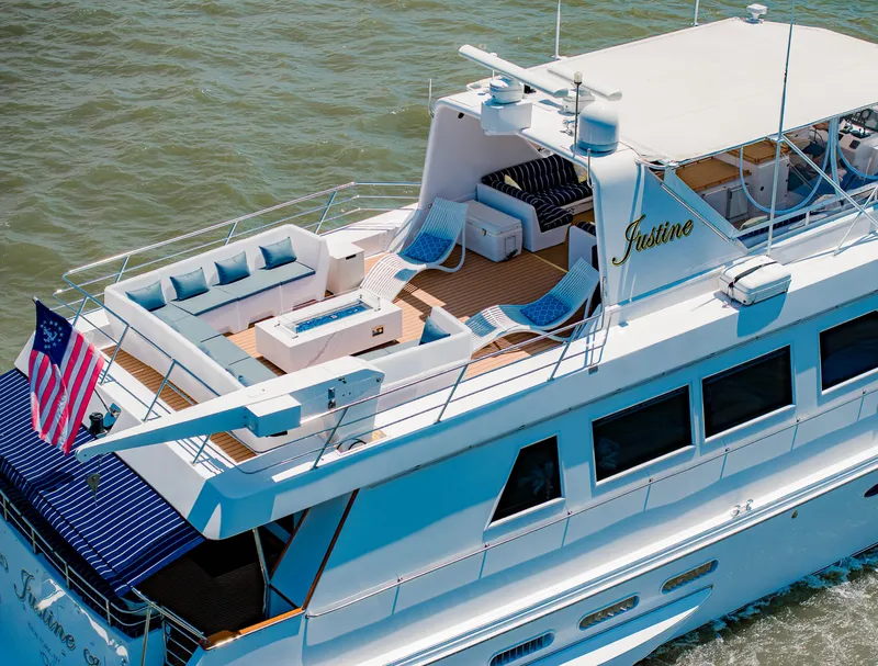 Slide: The Image of Luxurious 1987 Guy Couach 97 yacht with spacious deck and seating, cruising on open water. - 12