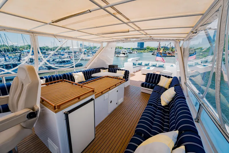 Slide: The Image of Luxurious 1987 Guy Couach 97 yacht deck with striped seating and marina view. - 18