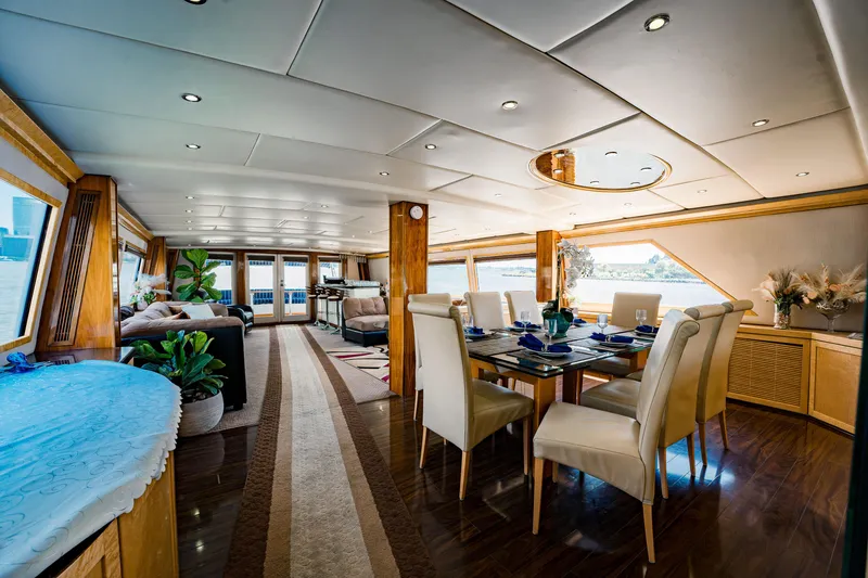 Slide: The Image of Luxurious interior of 1987 Guy Couach 97 yacht with elegant dining area and panoramic windows. - 24