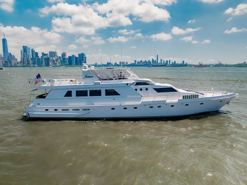 Slide: The Image of 1987 Guy Couach 97 yacht cruising near city skyline under blue sky. - 3