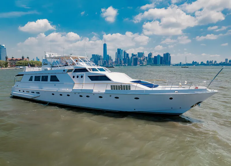 Slide: The Image of Luxurious 1987 Guy Couach 97 yacht cruising near a city skyline under a blue sky. - 4