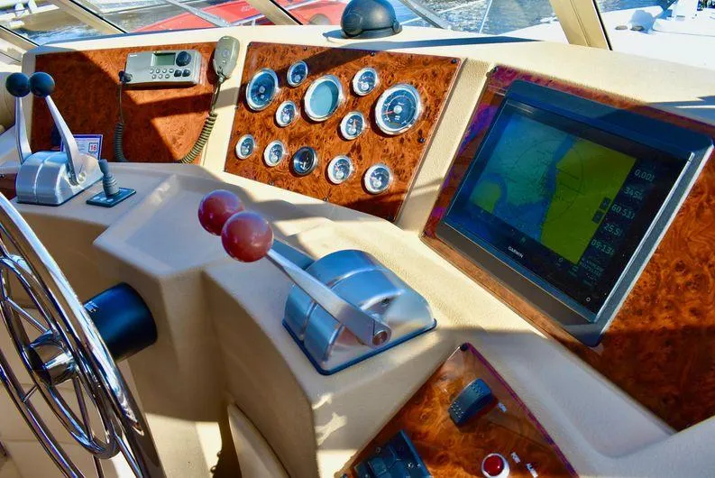 Slide: The Image of 2004 Meridian 490 Pilothouse dashboard with navigation screen and control levers. - 14