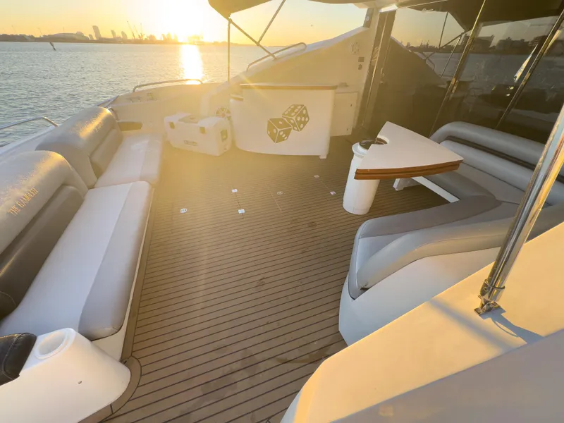 Slide: The Image of Luxurious Sunseeker Predator 82 yacht deck with sunset view, featuring elegant seating and table. - 12