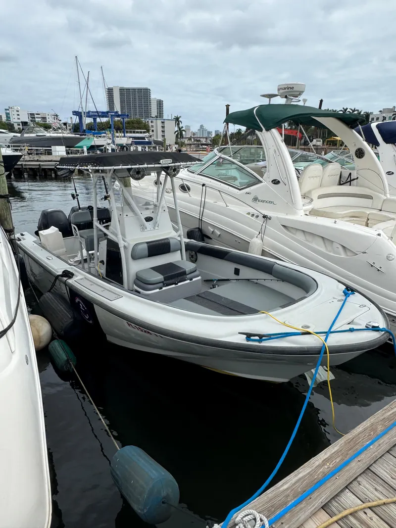 Slide: The Image of 2005 Boston Whaler Justice 240 docked at marina, surrounded by other boats. - 3
