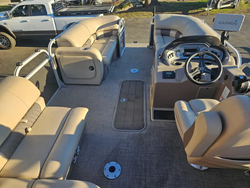 Slide: The Image of 2023 Sun Tracker Party Barge 22 XPB interior with beige seating and Garmin navigation. - 14
