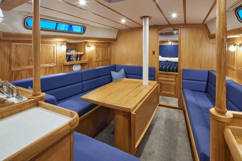 Slide: The Image of Luxurious 2025 Rustler 42 yacht interior with blue seating and wooden finishes. - 10