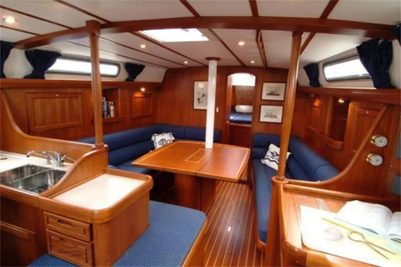 Slide: The Image of Luxurious interior of 2025 Rustler 42 yacht with wooden finish and blue seating. - 12