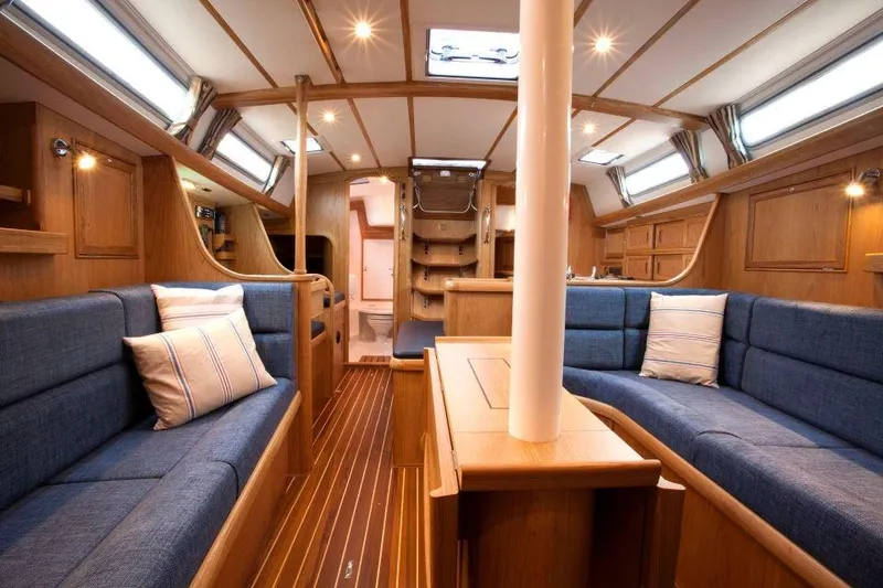 Slide: The Image of Luxurious interior of 2025 Rustler 42 yacht with wooden finish and blue seating. - 14