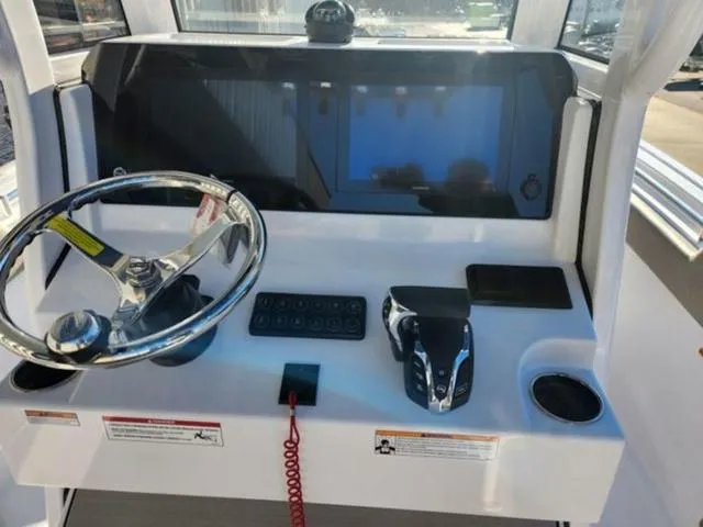 Slide: The Image of 2025 Sportsman Heritage 231 boat on trailer, blue hull, parked outside dealership. - 10