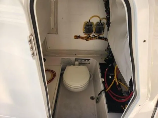 Slide: The Image of 2025 Sportsman Heritage 231 boat interior with toilet and wiring. - 23