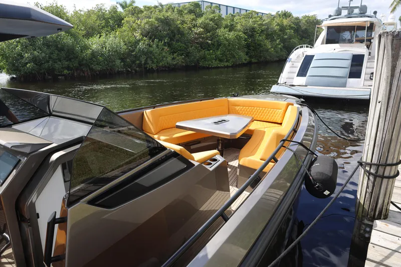 Slide: The Image of 2021 Vanquish Yachts VQ40 with orange seating, docked near lush greenery. - 13