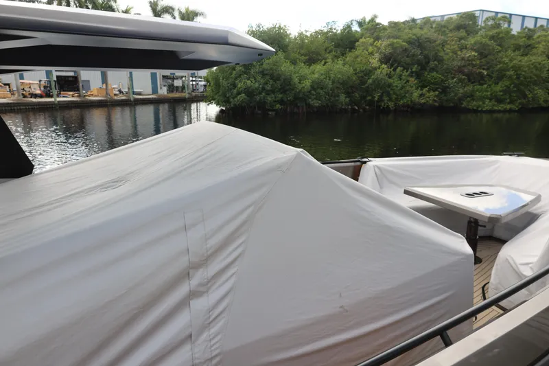 Slide: The Image of Vanquish Yachts VQ40 2021 covered boat docked near lush greenery. - 23