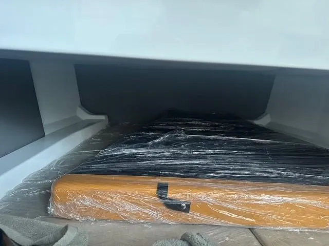 Slide: The Image of Storage compartment of 2021 Vanquish Yachts VQ40, featuring wrapped wooden item. - 30
