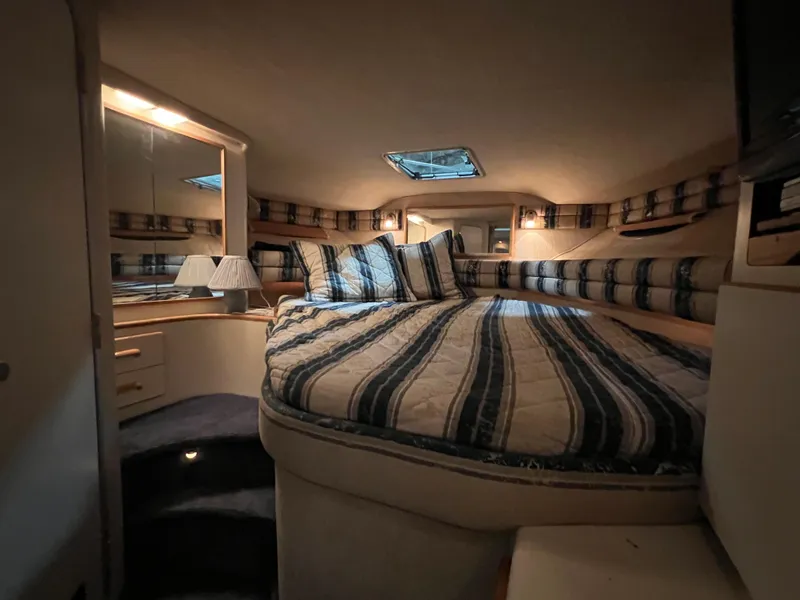 Slide: The Image of Cozy cabin interior of 1992 Sea Ray 370 Express Cruiser with striped bedding and ambient lighting. - 18