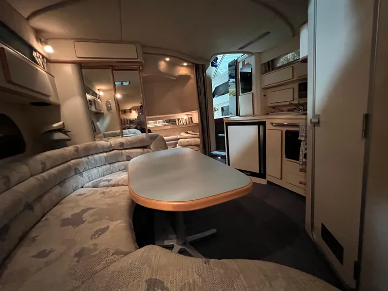 Slide: The Image of Interior of 1992 Sea Ray 370 Express Cruiser with cozy seating and kitchenette. - 21