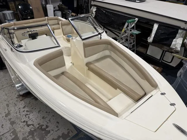 Slide: The Image of 2021 Scout 210 Dorado boat with beige seating and sleek design in a workshop setting. - 6