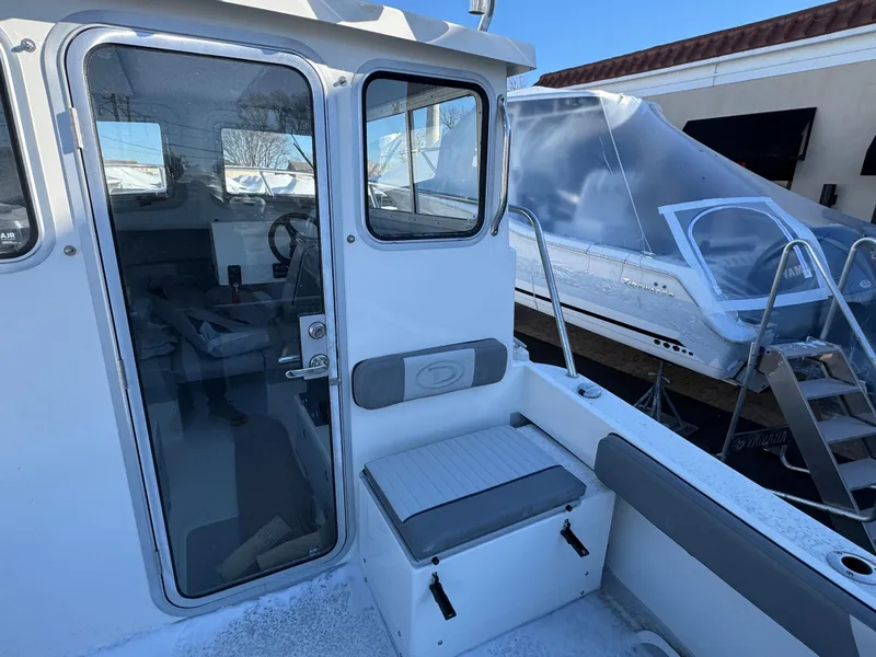 Slide: The Image of 2025 Defiance Admiral 220 EX boat interior with seating and window view. - 12