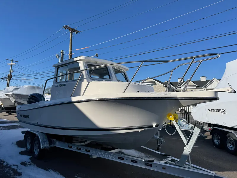 The Image of 2025 Defiance Admiral 220 EX boat on trailer, parked outdoors. - 1