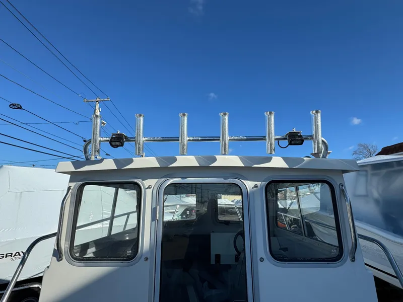 Slide: The Image of 2025 Defiance Admiral 220 EX boat cabin under clear blue sky. - 14