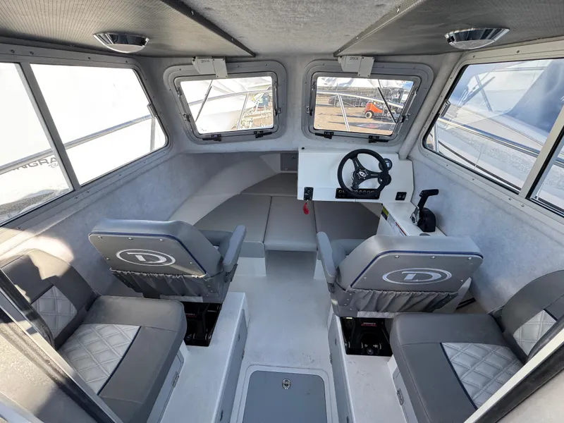 Slide: The Image of Interior of 2025 Defiance Admiral 220 EX boat, featuring seating and steering console. - 3